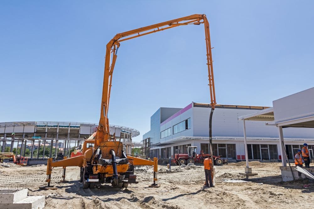 Orange Concrete Pump on Construction Site — Far Northern Concrete Pumping in Cairns, QLD